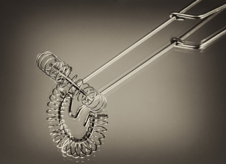 whisk, kitchen tools made of stainless steel on a white batskground, retro, vintage, black and white photo, closeupの写真素材