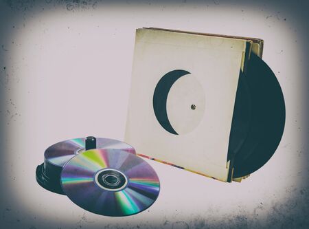 vinyl records and cd CD-R, DVD on a white background. isolated; retro style, vintage, old photo