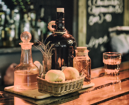 still life tools on the bar, bottles in blurred background, warm light, retro style photoの写真素材