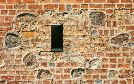 outdated medieval window in horizontal composition with old wall stoneの写真素材