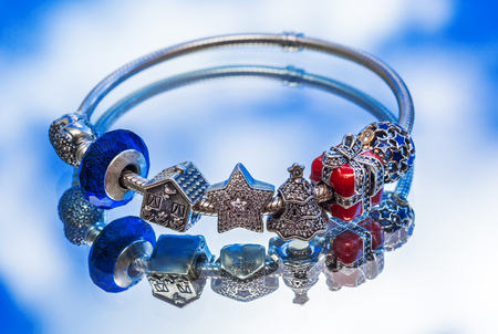 jewelry bracelet female on a blue surface, modern fashion, charms, jewelry, macroの写真素材