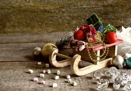 Christmas gift boxes and sleigh with presents on an old wooden surface, space for text, retro styleの写真素材