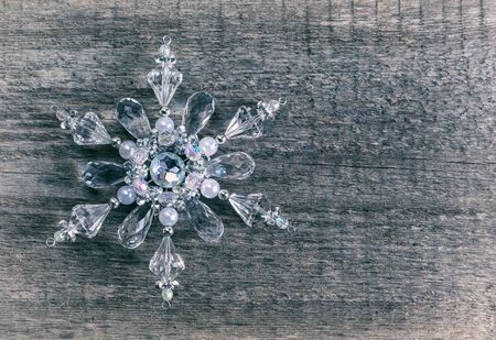 Christmas Gift snowflake made of glass on an old wooden surface, space for text, retro styleの写真素材