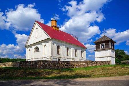 Church of the Assumption of the Blessed Virgin Mary on a background of blue sky with clouds, old architecture, religious places, Belarus, Village Pleban, Molodechno Districtの写真素材