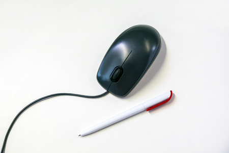 Office supplies pen with computer mouse on white background, business objects, close-up, place for textの写真素材