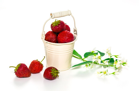 Beautiful bouquet of fresh strawberries in a decorative bucket
  on a white background.の写真素材
