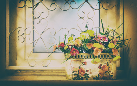 A bouquet of bright artificial flowers in a pot. Creative image, retro styleの写真素材