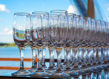 wine wine glasses lined up on a table against the blue sky. view of the lake. celebration, holiday. selective focusの写真素材
