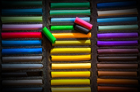 Closeup of colorful chalk pastels in a box for drawing. View from above; retro style