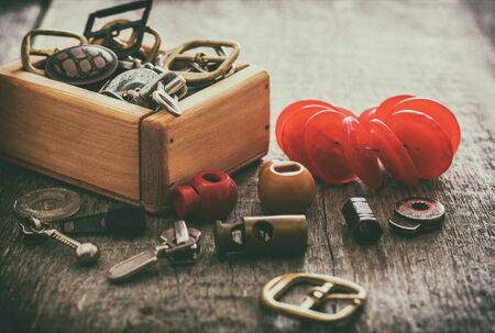 Creative image of sewing fittings and accessories for sewing clasps, clamps, buttons on the old wooden surface. selective focus. Retro styleの写真素材