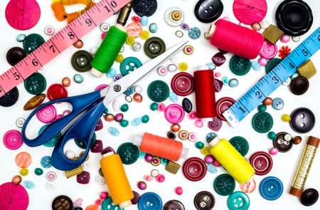 Sewing accessories for handmade sewing on a white background a spool of thread, scissors, buttons. Set for needlework. View from above.の写真素材
