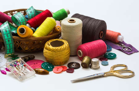 Old sewing accessories for sewing handmade on a white background, a spool of thread, scissors, buttons. A set for needlework.の写真素材