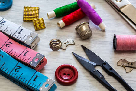 Various accessories for needlework. A set of sewing supplies for fabrics and spools of thread, scissors and a thimble.の写真素材