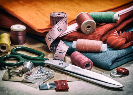 Various accessories for needlework. A set of sewing accessories for sewing, spools of thread, fabrics, scissors and thimble close-up. Creative image. Retro styleの写真素材