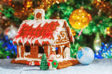 Christmas fairy waffle house with a snowman and toys on the background of a festive Christmas tree. New Year card. Christmas still life. Fabulous village. Place for textの写真素材