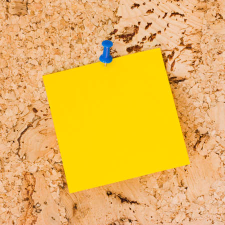 Yellow post-it paper on cork boardの写真素材