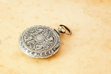 Ancient pocket watch over sepia backgroundの写真素材