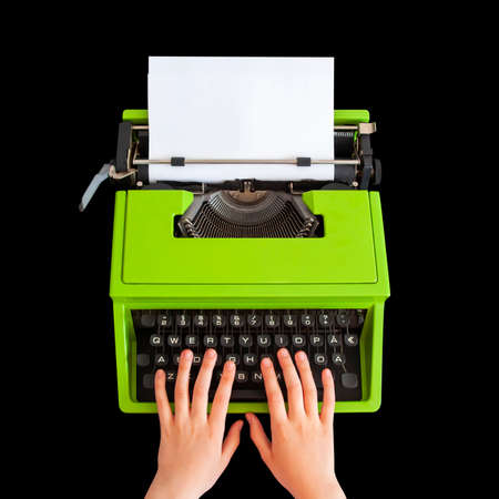 Hands typing on retro typewriter over black background