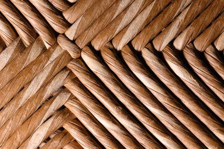 The strips are intertwined, displaying a natural brown hue with visible grain and fibers. The close-up perspective highlights the meticulous weaving technique.の写真素材