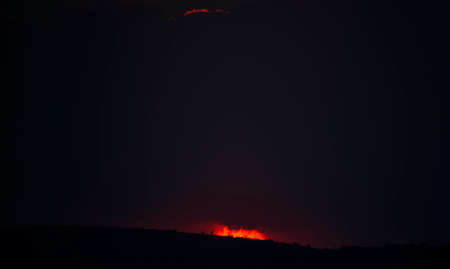 sun setting over the horizon at dusk with a dramatic sky of intense colorsの写真素材