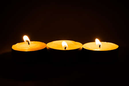 Candles, burning scented candles on a black background for any purposeの写真素材