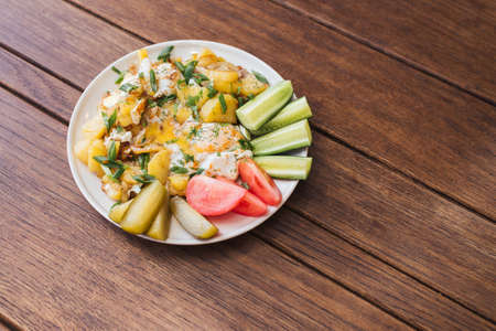 Fried potatoes with egg, fresh cucumbers and tomatoes  for any purposeの写真素材