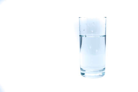 Clean drinking water poured into a glass on a light background for any purposeの写真素材