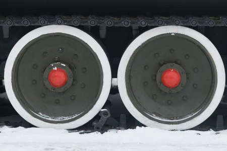 Wheels and tracks of an old tank on snow for any purposes