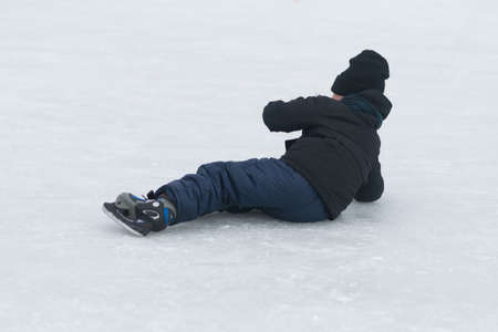 Fallen child in the winter rink for all purposesの写真素材