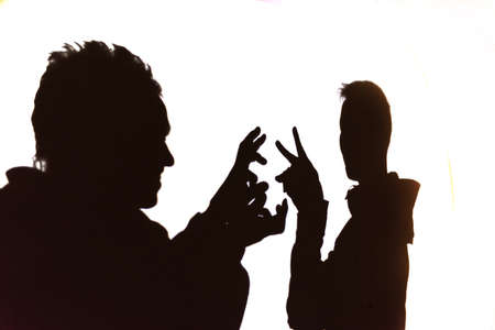 Shadow theater.Silhouettes of people isolated on white backgroundの写真素材