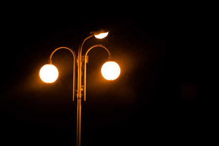 A lighted lantern on a pole, in the dark, for any purposeの写真素材
