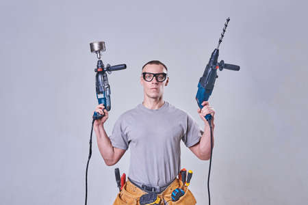 Master-Builder-finisher in their working clothes, with two hammers in his hands for any purposeの写真素材