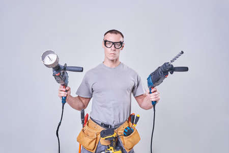 Master-Builder-finisher in their working clothes, with two hammers in his hands for any purposeの写真素材