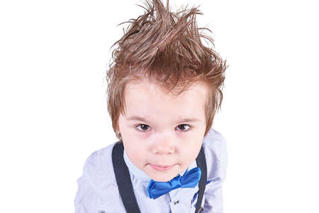 Beautiful little boy in blue bow tie and a green sweater, smiling isolated on white background for...