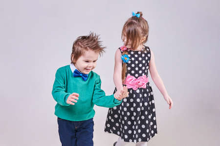 Beautiful little boy and girl holding hands, for any purposeの写真素材