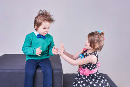 Beautiful little boy and girl clap their hands and smile for any purpose