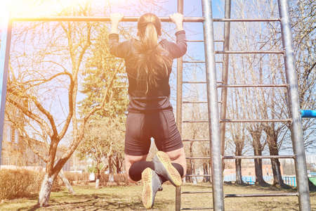 Sports girl on the crossbar for any purpose