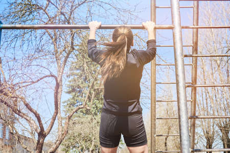 Sports girl on the crossbar for any purpose