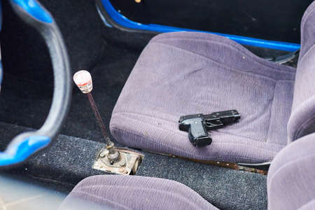 Gun in the front seat of the car for any purposeの写真素材