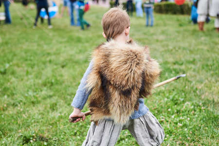 Little boy barbarian with a spear, from the back for any purposeの写真素材