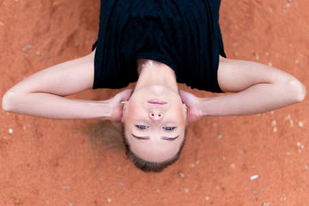 Beautiful athletic girl trains abdominal muscles on a street simulator. For any purposeの写真素材