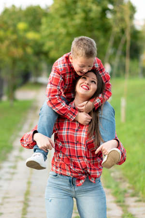 Mom, smiling, carries a son on his shoulders. For any purpose.の写真素材