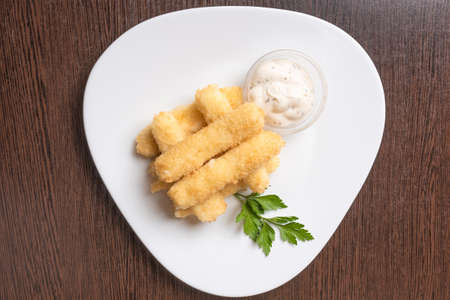 Cheese sticks breaded, with sauce and herbs, on a platter. For any purpose.の写真素材