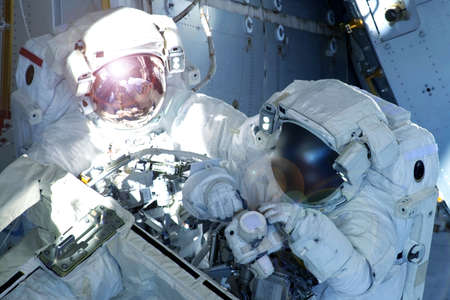 Astronaut in a spacesuit. At the space station. Engaged in maintenance.. Elements of this image were furnished by NASA. For any purpose.の写真素材