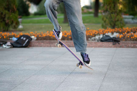 Men's legs, on a skateboard, with tricks. For any purpose