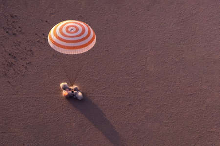 Space shuttle landing in a field by parachute. Elements of this image were furnished by NASA. For...