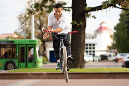 A young guy on a BMX bike, wraps the steering wheel in a jump. For any purpose.の写真素材