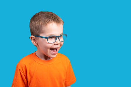Little boy in glasses is very surprised. Isolated on a blue background.の写真素材