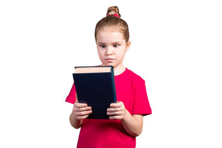 The little girl looks in surprise at an old book. Isolated on a white background. For any purpose.