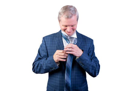 An elderly man straightens, knots a tie. Isolated on a white background. For any purpose.